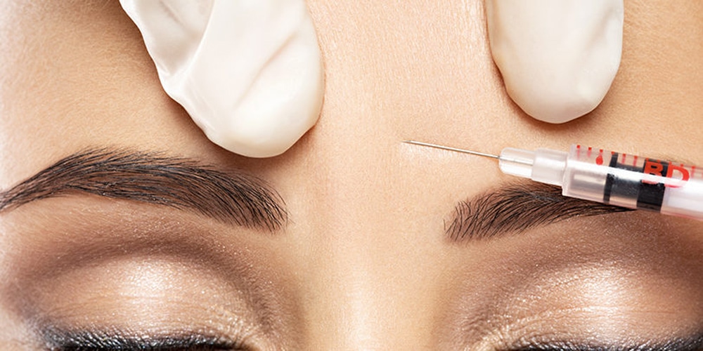 close up of Woman's forehead, doctor pushing needle into forehead