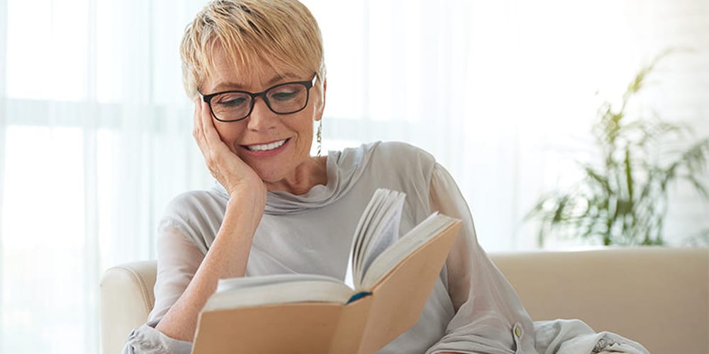 woman wearing glasses reading a book