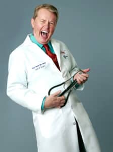 Dr. Paul Vanek laughing at the camera, holding his stethoscope like a guitar