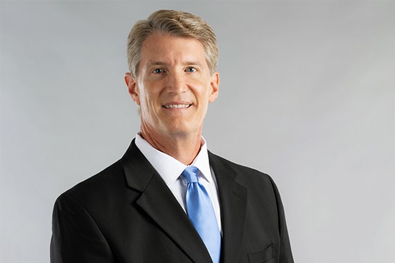 Headshot of a business man with a grey background--stock photo for procedures section of website for Mentor Plastic Surgery and MedSpa