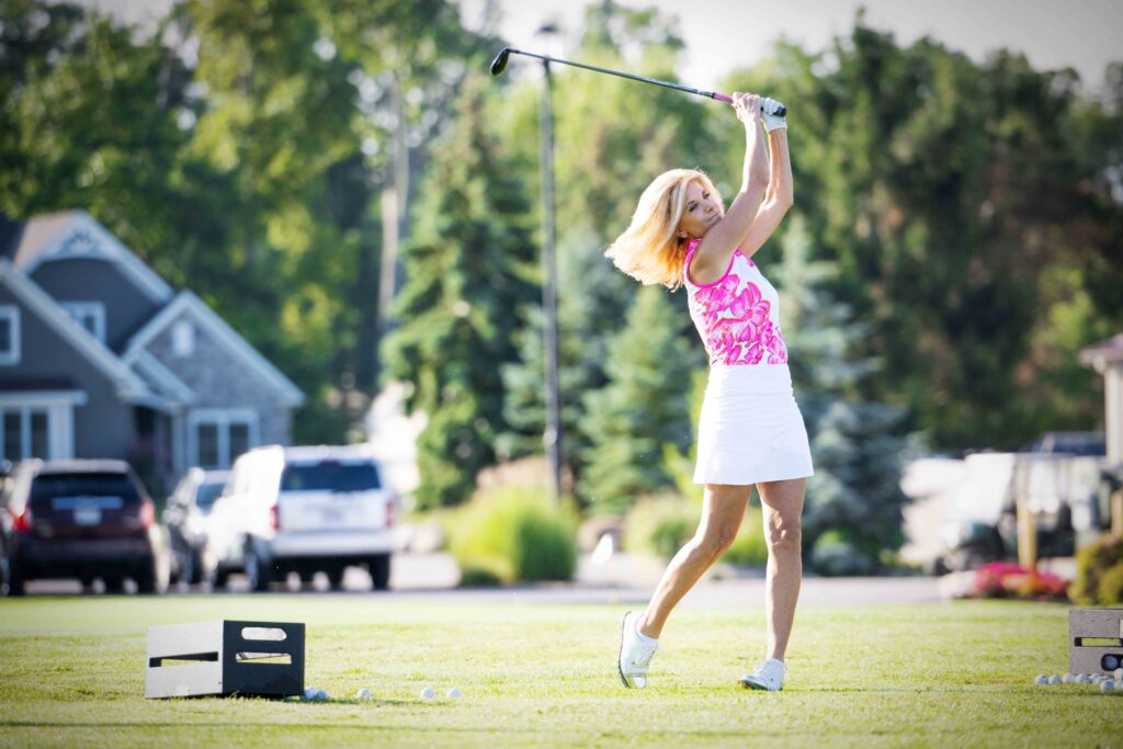 Woman in pink golf top golfing outdoors