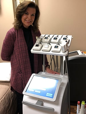 Photo of Mary Jo posing and smiling with truSculpt iD machine